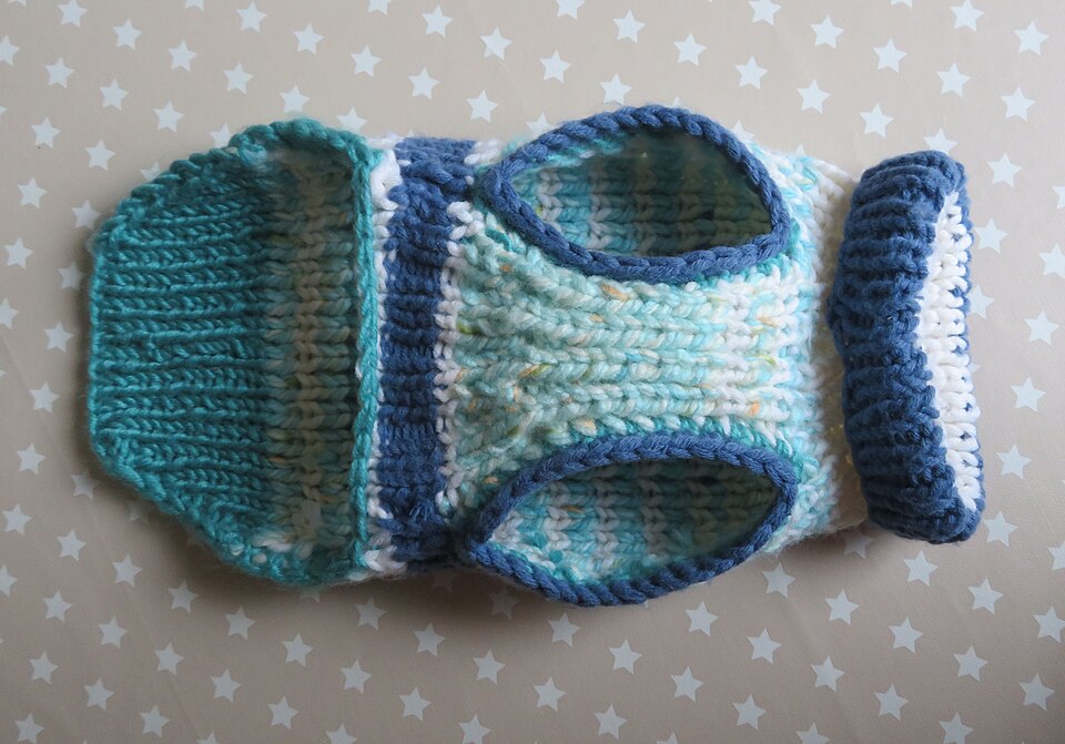 A knitted dog sweater in blue and teal tones